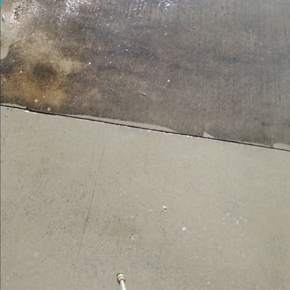 Concrete before and after at expansion joint — dirty top, cleaned bottom