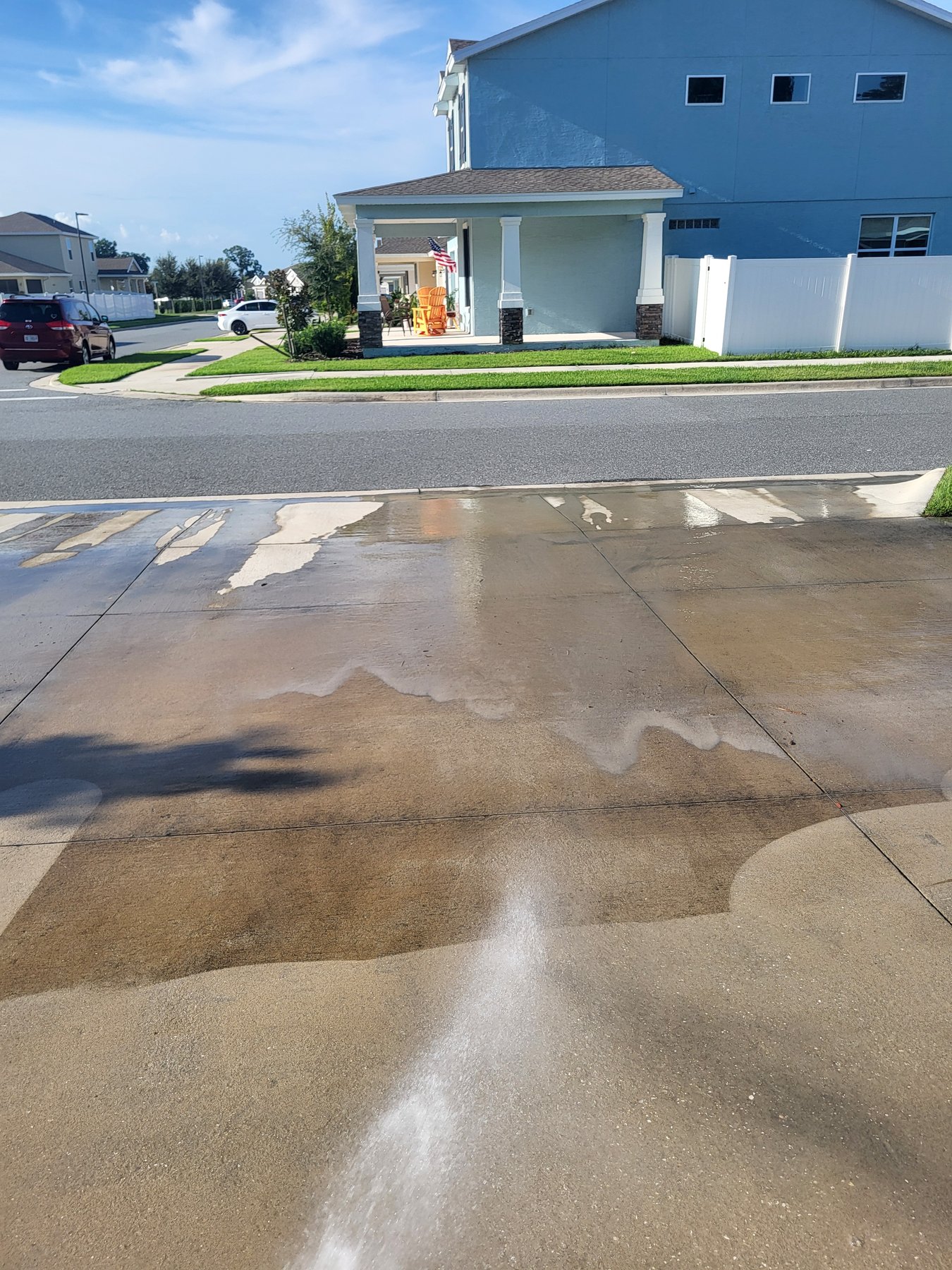 Driveway cleaning in progress — clean versus dirty spray contrast