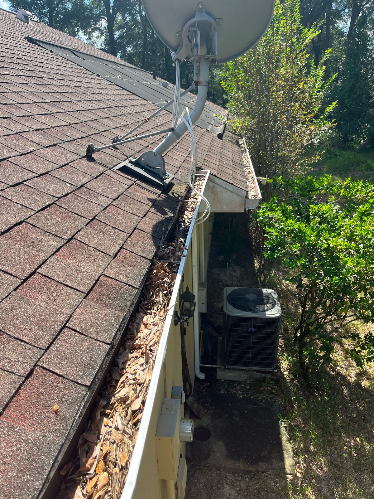 Gutter before — leaf clog near satellite dish and AC unit