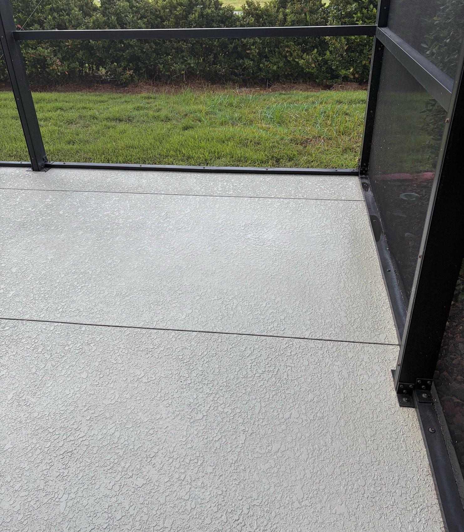 Lanai floor after cleaning — textured cool deck inside screen enclosure