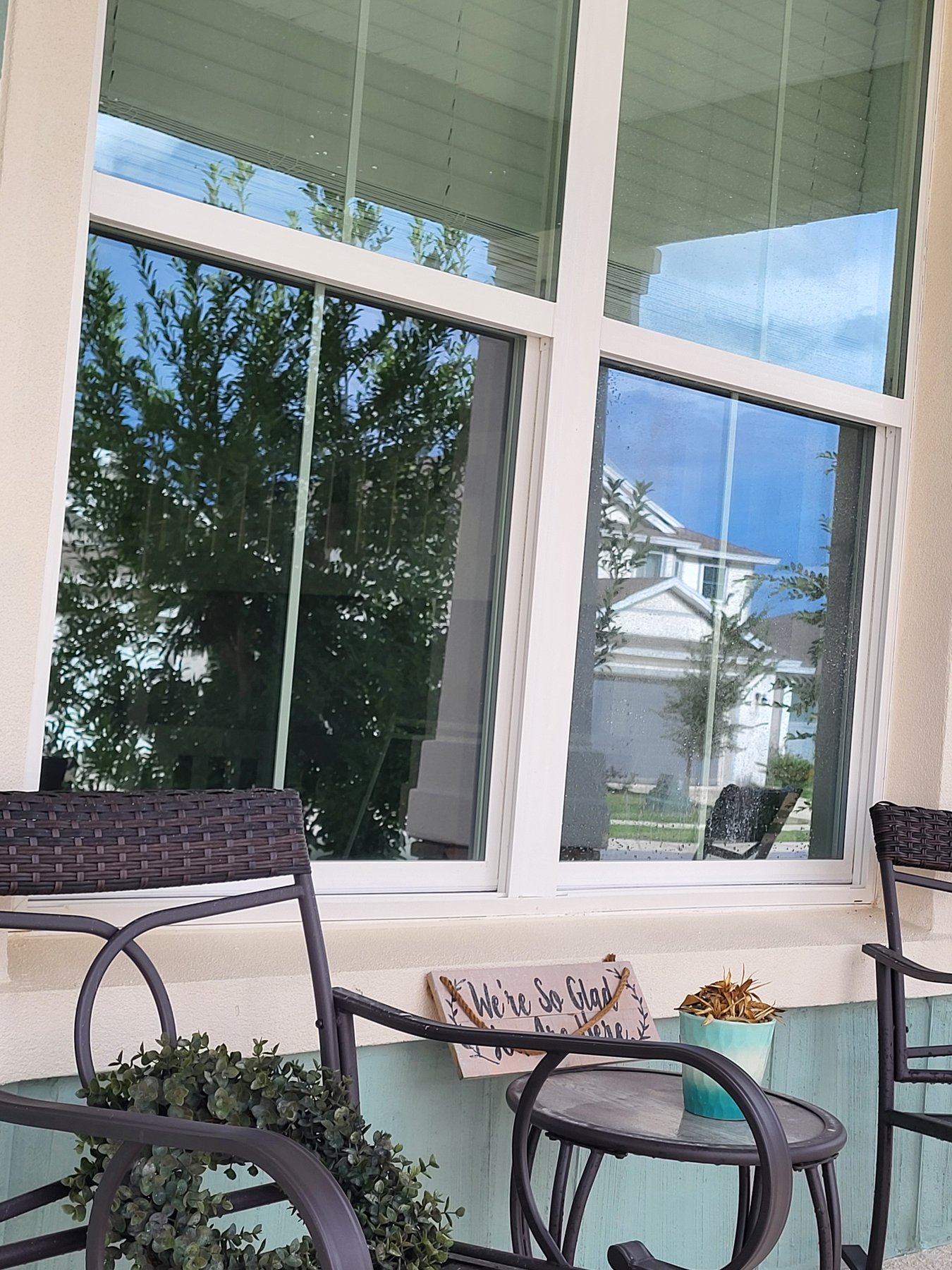 Clean porch window after cleaning — clear glass with wicker and welcome sign
