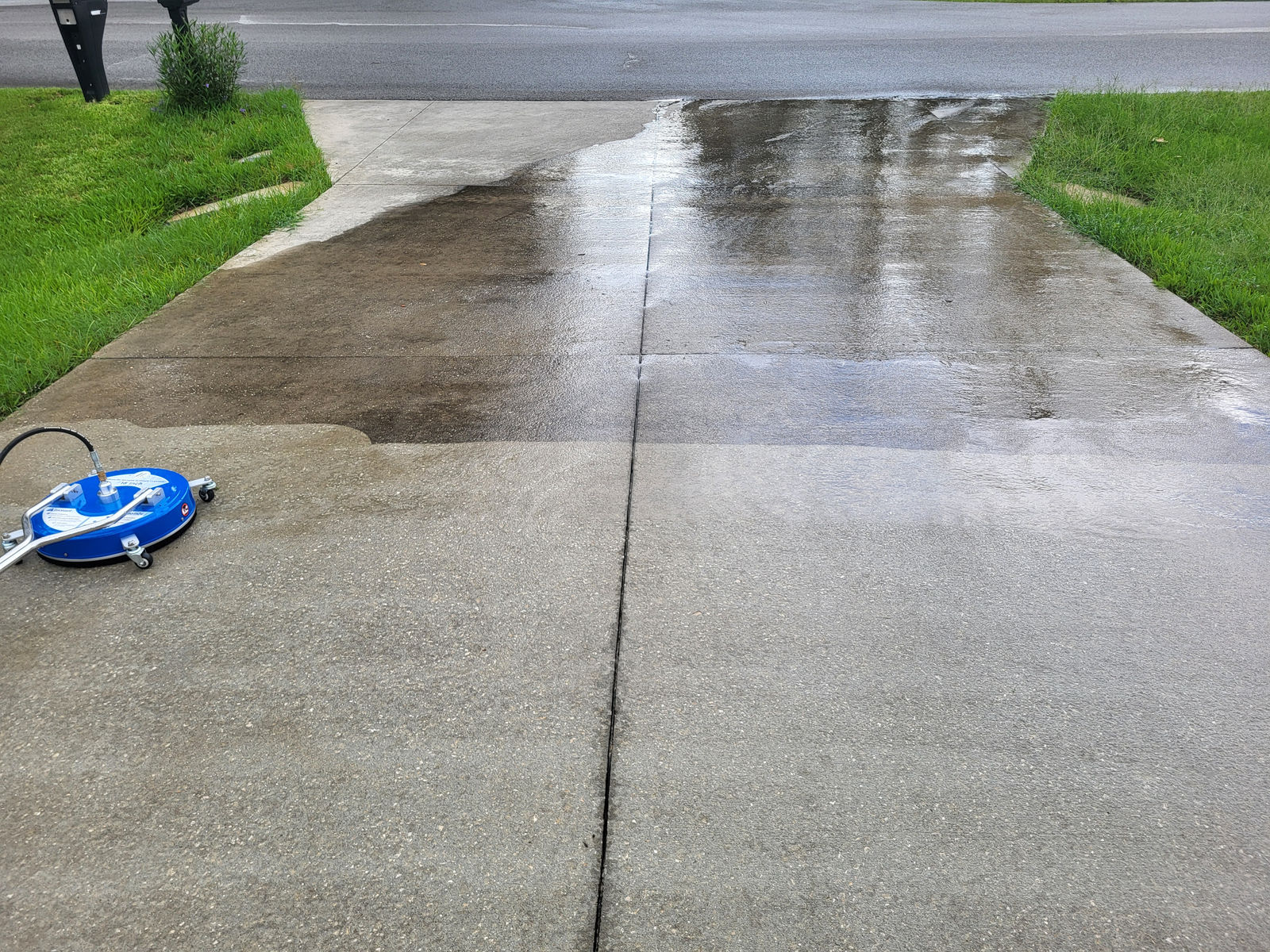 Driveway cleaning in progress — surface cleaner on concrete with clean vs dirty contrast
